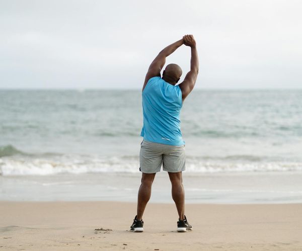 Man stretching outdoors feeling energized and refreshed by nature.